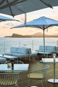 a deck on a boat with chairs and umbrellas at CALEA Boutique Hotel in Bacoli