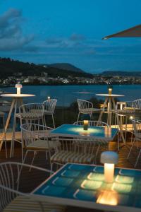 a deck with tables and chairs and a view of the water at CALEA Boutique Hotel in Bacoli