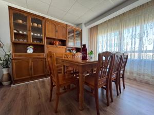 a dining room with a wooden table and chairs at Fogar Rivoira Sacrata in Castro Caldelas