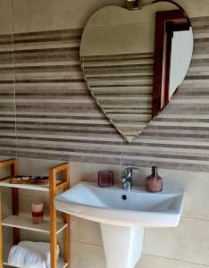 a bathroom with a sink and a heart shaped mirror at Denisa in Limanu +74 photos