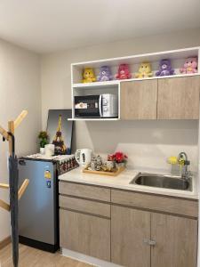 a kitchen with a sink and a microwave at Double J Room the east ville Bangsean in Ban Hua Khao Sammuk
