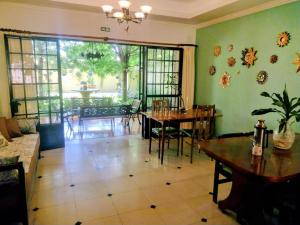 een eetkamer met een tafel en stoelen en een groot raam bij SOLES Hostel Boutique in Rosario