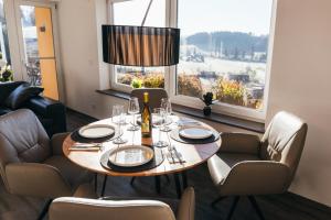 a dining room with a table and chairs and windows at Ferienwohnung Alpenblick I Kamin I private Sauna in Wangen im Allgäu