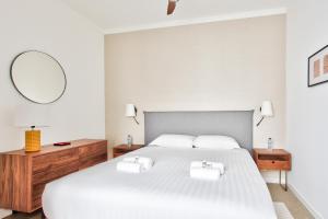 een slaapkamer met een groot wit bed met een spiegel bij Marais Elegence Suites - Two bedrooms in Parijs