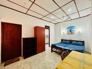 ヒッカドゥワにあるGolden Beach Guest House and Restaurantのベッドとテーブルのある寝室