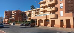 un edificio con coches aparcados al lado de una calle en Vista Atlántico, en Isla Cristina