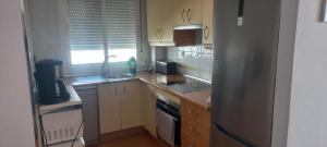 Una cocina con frigorífico de acero inoxidable y fregadero. en Vista Atlántico, en Isla Cristina