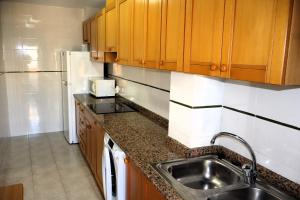 a kitchen with a sink and a refrigerator at Los Pescadores playa LEK in Peñíscola