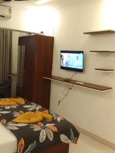 ein Zimmer mit einem Bett und einem Fernseher an der Wand in der Unterkunft Anu'S 2 Luxury studio resrt apart close to candolim beach for 5ppl in Candolim