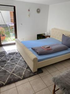 una camera da letto con un letto con una coperta blu e una finestra di Ferienwohnung Eschbach Hof 2 am Nürburgring a Herresbach
