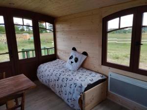 una camera con un letto in una cabina con finestre di Séjour pittoresque en roulotte équipée - FR-1-410-455 a Cérans-Foulletourte