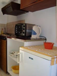 a kitchen with a microwave on top of a refrigerator at Hotel Elida in Platanes