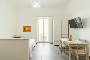 a white room with a bed and a table with chairs at Dimora Borbonica in Ercolano