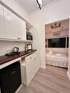 a kitchen with white cabinets and a bed in a room at Studio Two Condominium - Alabang, BLK - Northgate Cyberzone, Filinvest City, Alabang - Netflix-ready Fiber Wi-Fi in Manila