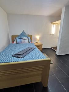a bedroom with a bed with a blue comforter at Monteurwohnung Biedenkopf in Biedenkopf