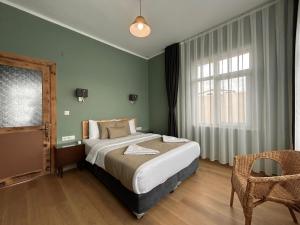 une chambre avec un lit, une chaise et une fenêtre dans l'établissement Waterfront Villa by the Tram - Private Terrace with Dome & Golden Horn View in Fatih, à Istanbul