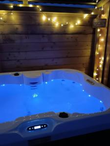 a large tub with lights in a room at Chalet Cosy avec option Jacuzzi in Saint-Genès-de-Fronsac +4 photos