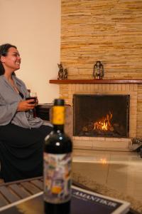 uma mulher segurando um copo de vinho em frente a uma lareira em Pousada Serra do Jordão by Concavus em Campos de Jordão mais 35 fotografias