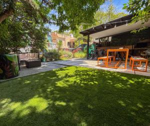 a backyard with a lawn with two chairs and a table at Destino26 Hostel in Montevideo