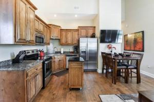 a kitchen with wooden cabinets and a table and a refrigerator at Penthouse Lakeview Haven in Branson