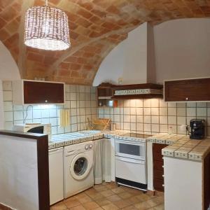 a kitchen with a washing machine and a washer at Casa Blava in Castelló d'Empúries