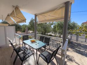 a patio with a table and chairs on a balcony at Sivi's Vacation Homes in Skala Kallirachis