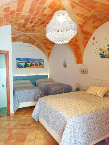 a bedroom with two beds and a chandelier at Casa Blava in Castelló d'Empúries
