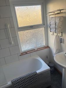 a bathroom with a bath tub and a window at Morecambe Bay Cottage in Morecambe