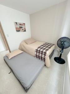 a room with two beds and a fan in it at Apartamento NUEVO, moderno e inteligente in Ibagué +15 photos