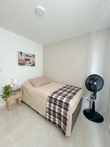 a bedroom with a bed and a fan in it at Apartamento NUEVO, moderno e inteligente in Ibagué