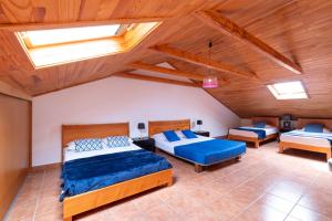 a bedroom with two beds and a ceiling with skylights at Casa del Mar I by GALMI in Arco de São Jorge