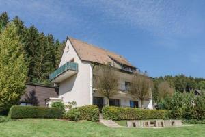a large white building with a balcony in a yard at Landhaus Mettenberg in Niedersalwey