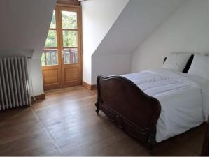 a bedroom with a bed and a window and a door at Appartement des écuries in Château-Chervix