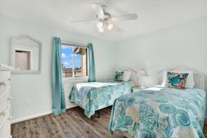 a bedroom with two beds and a ceiling fan at Lighthouse Point Rental 2C in Tybee Island +40 photos