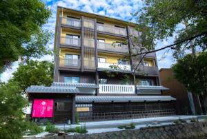a tall building with a pink sign in front of it at Kyoto Takasegawa Bettei - Vacation STAY 69818v in Kyoto