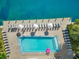 an overhead view of a swimming pool with chairs and water at Amazing Studio with Balcony & Pool in Hallandale Beach