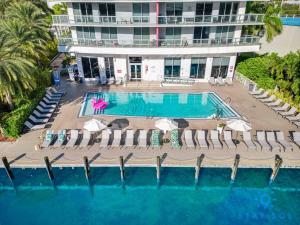 an aerial view of a pool with chairs and a building at Amazing Studio with Balcony & Pool in Hallandale Beach +23 photos