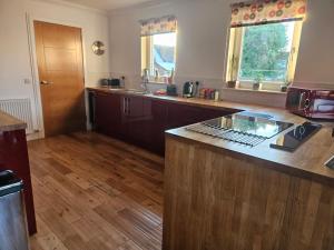 a kitchen with a counter top and wooden floors at Beolary in Oban