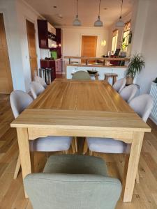 a wooden table with chairs and a kitchen in the background at Beolary in Oban
