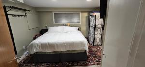 a bedroom with a bed with white sheets and a window at 1 block to Kelowna General Hospital 2 blocks to Beach 1km to OUC 1km to Downtown Kelowna 20min to YLW in Kelowna