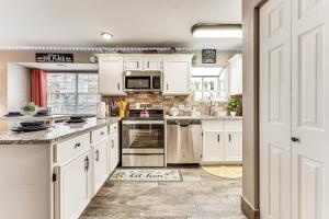 a kitchen with white cabinets and a stove top oven at 1 Mi to Silver Dollar City! Lake-View Family Haven in Branson
