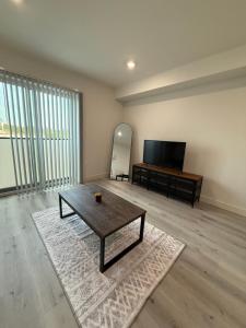 洛杉矶Modern House Santamonica的客厅配有咖啡桌和平面电视。