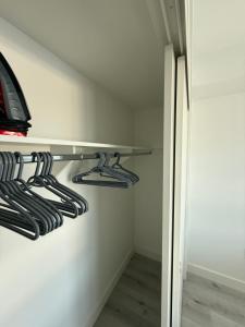 洛杉矶Modern House Santamonica的白色墙上挂有衣架的衣柜