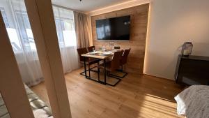 Un comedor con una mesa y un televisor de pantalla plana. en WALDNEST - Apartment Seefeld, en Seefeld in Tirol