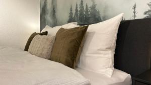 una cama con varias almohadas encima en WALDNEST - Apartment Seefeld, en Seefeld in Tirol