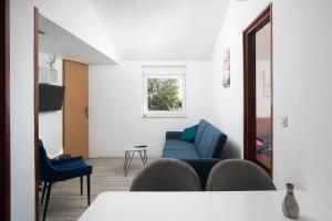 a living room with blue chairs and a mirror at APARTMENT MAJER 2 in Medulin