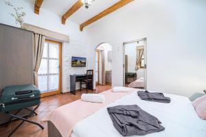 ブクにあるRigótanya Relax & Wellness Panzió Bükfürdőの大きな白いベッドと机のある寝室