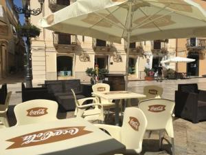 a table and chairs with an umbrella on a patio at Casa vacanze da Mely in Marsala