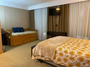 a bedroom with a bed and a dresser in it at Flat Hotel em Guarulhos in Guarulhos