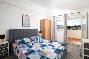 a bedroom with a bed with a checkerboardkered blanket at APARTMENT MAJER 2 in Medulin
